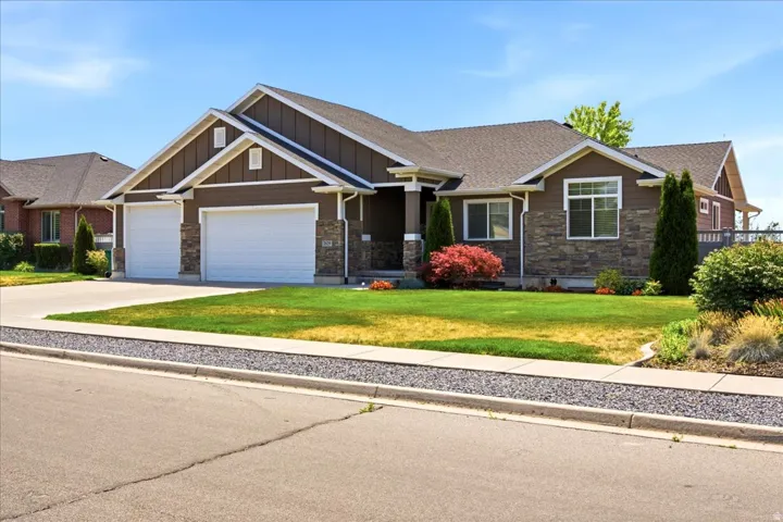 Front exterior featuring stone facade accents, dark siding, and white trim