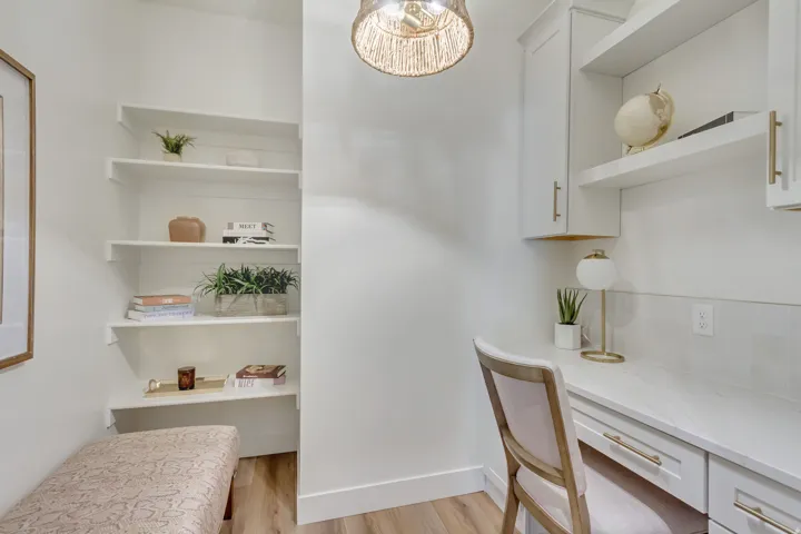 Dedicated workspace featuring a built-in desk with a white countertop and drawers