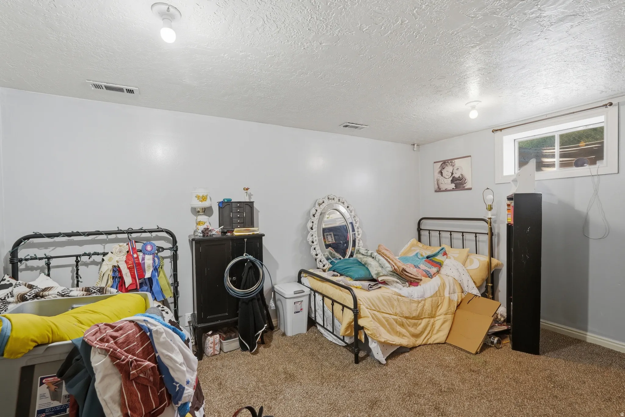 Carpeted room with a textured ceiling and light gray walls