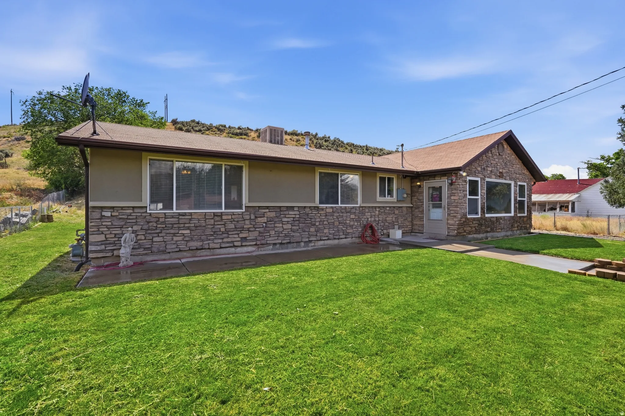 Ranch-style exterior with stone veneer accents and tan siding