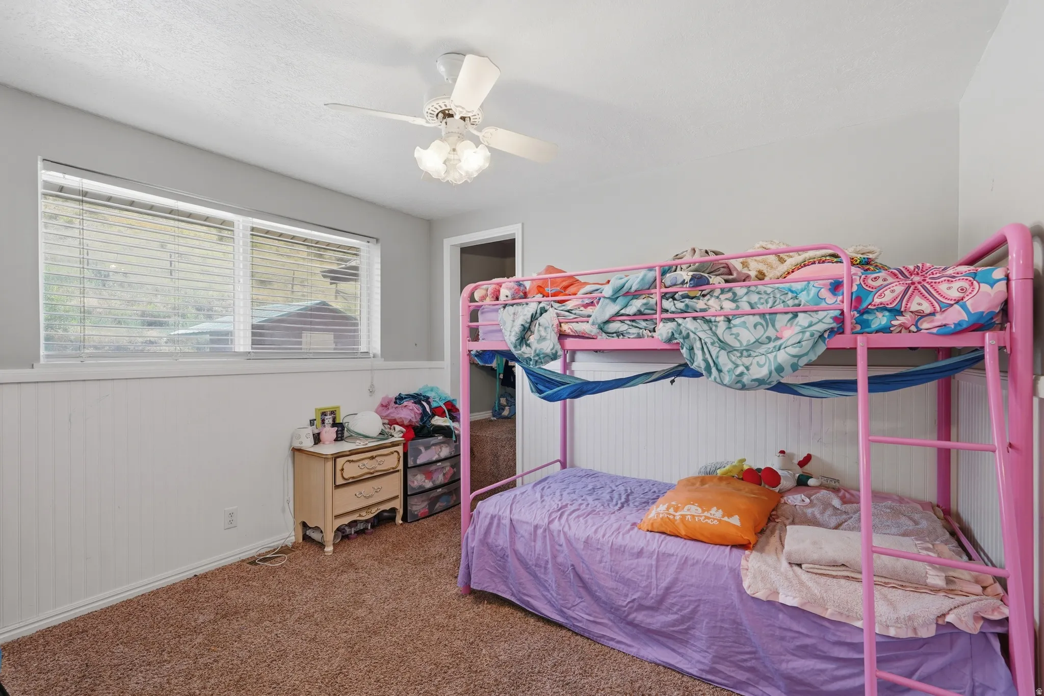 Light grey walls complemented by white beadboard paneling and textured carpet flooring