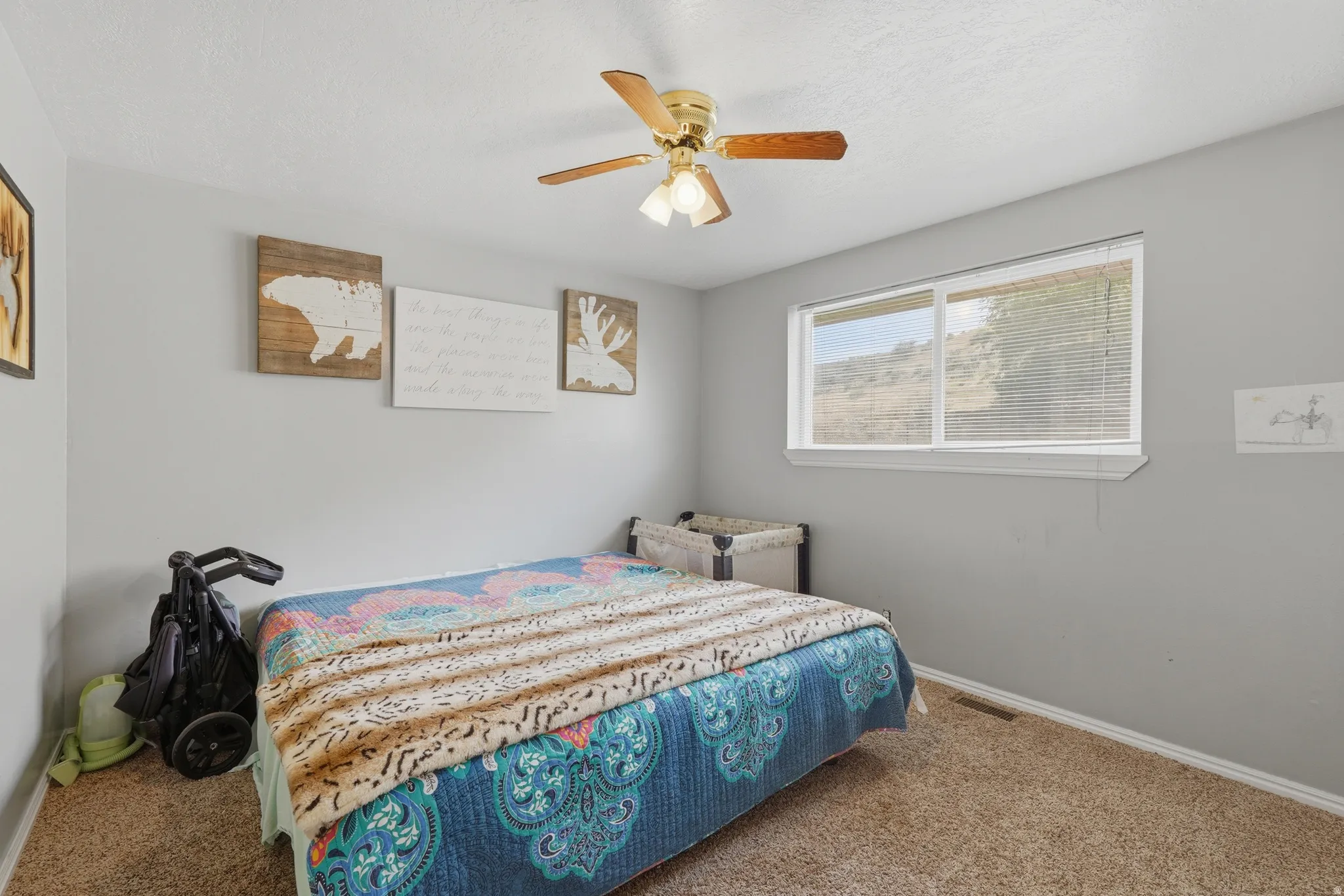 Bedroom featuring light gray walls, carpet flooring, and a ceiling fan with light fixture