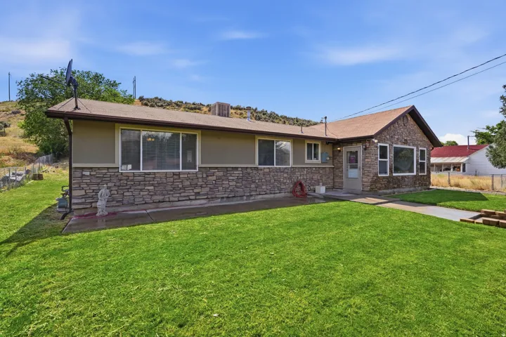 Ranch-style exterior with stone veneer accents and tan siding