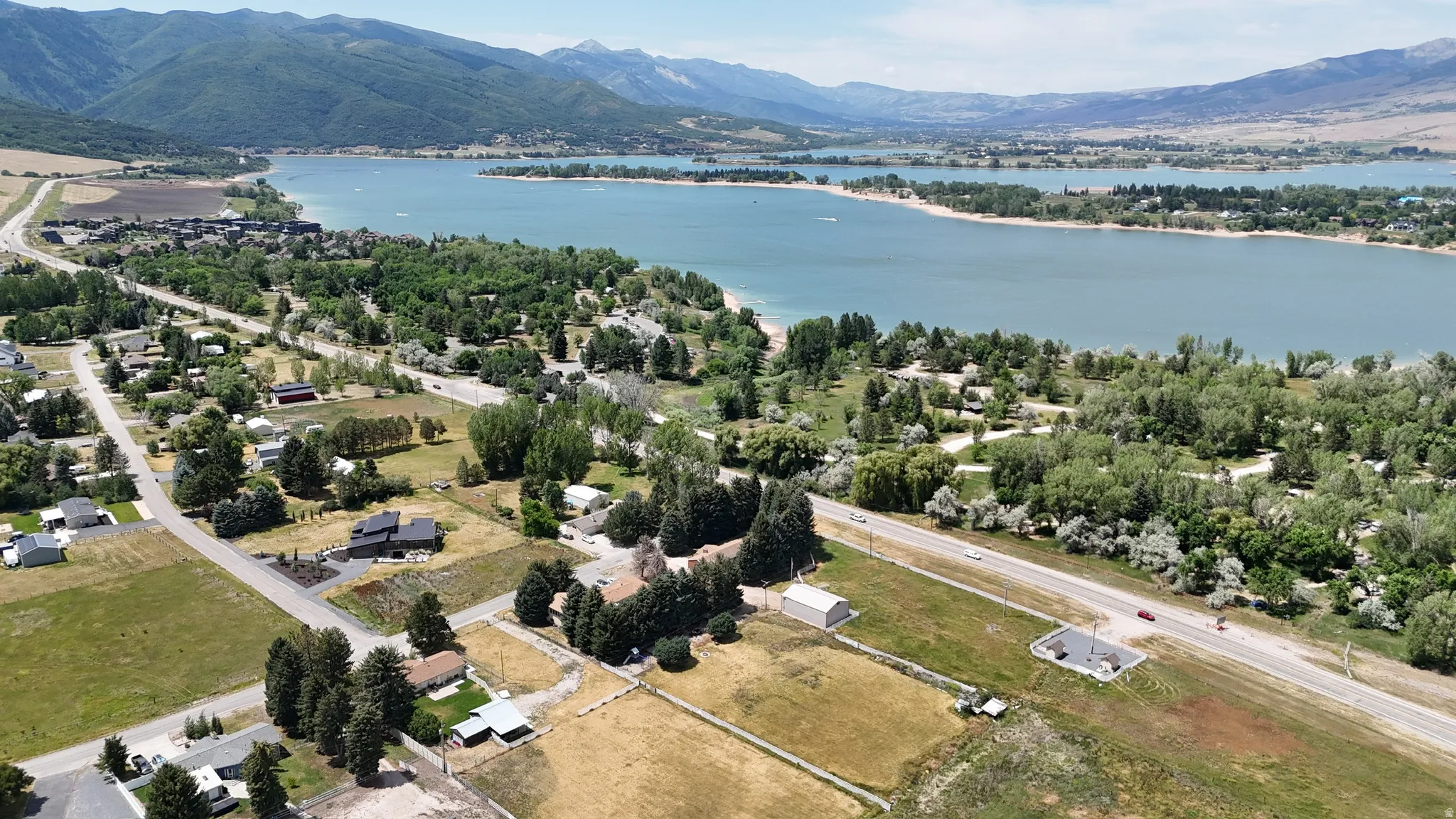 Expansive aerial perspective showcasing a lake with surrounding natural landscapes and distant mountains