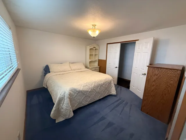 Bedroom featuring blue carpet and white walls
