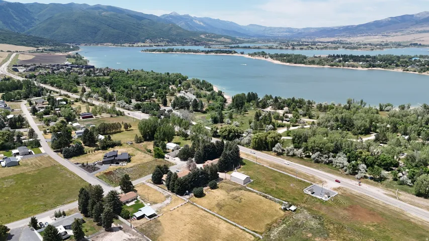 Expansive aerial perspective showcasing a lake with surrounding natural landscapes and distant mountains
