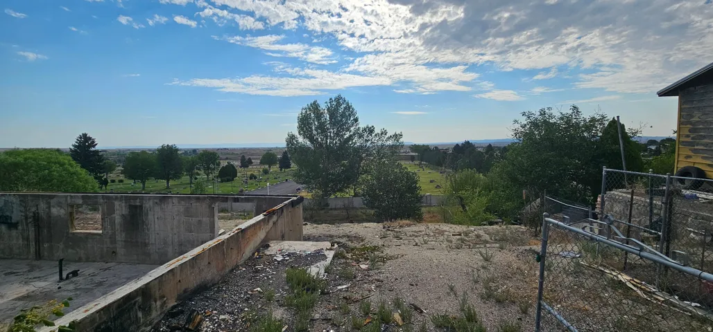 Concrete foundation and partial block wall structure featuring an expansive, tree-dotted landscape