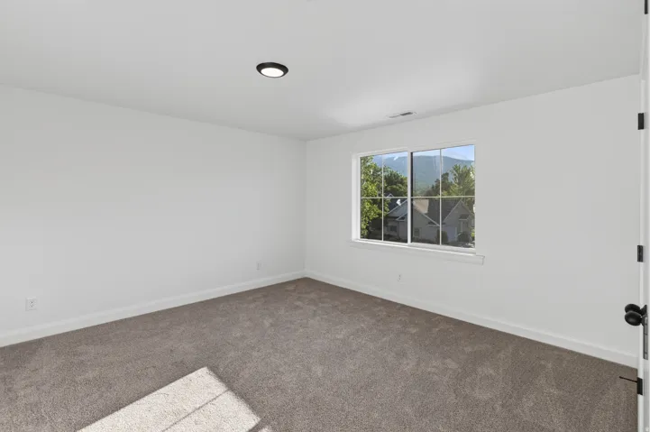 Neutral-toned wall-to-wall carpeting and crisp white walls