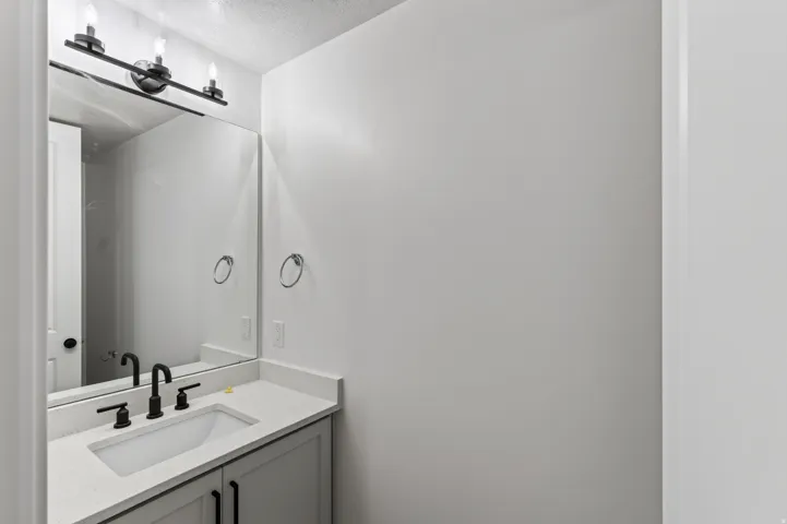 Modern vanity with an integrated sink, quartz-finish countertop, and matte black hardware