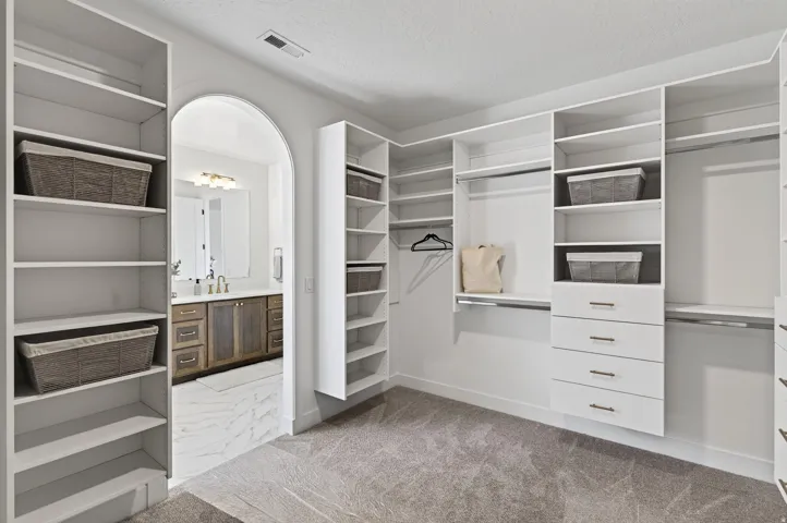 Customizable closet system with multiple shelving units, hanging rods, and integrated drawer storage