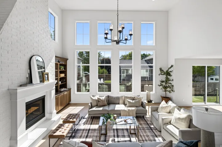 Vaulted living space with a white brick fireplace and built-in shelving