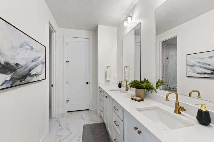 Dual vanity with integrated rectangular sinks, accented by gold-finish faucets and hardware