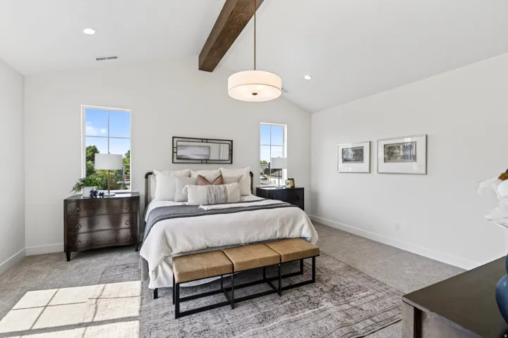 Vaulted ceiling featuring an exposed wood beam and a contemporary drum pendant light