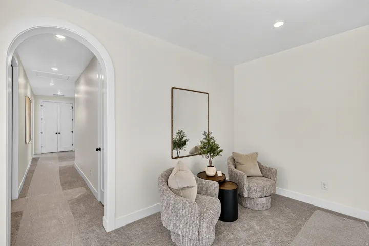 Archway entry to a hallway with recessed lighting, light neutral wall paint, and white baseboards