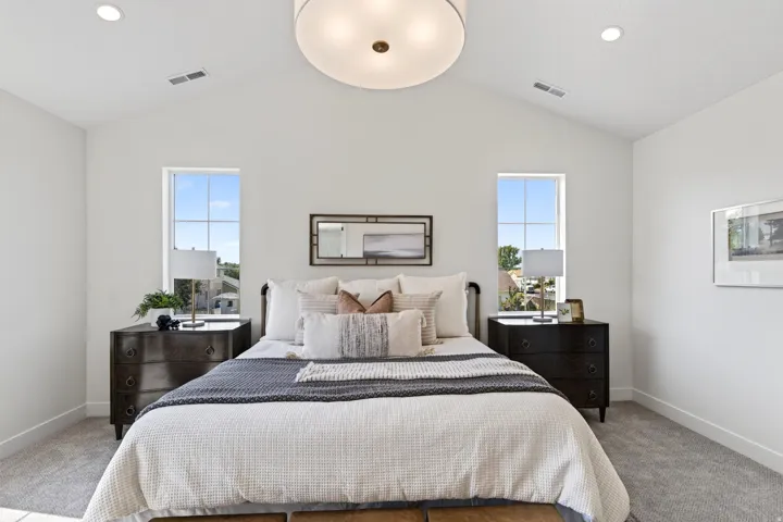Vaulted ceiling bedroom featuring two tall windows, recessed lighting, and a drum pendant light fixture