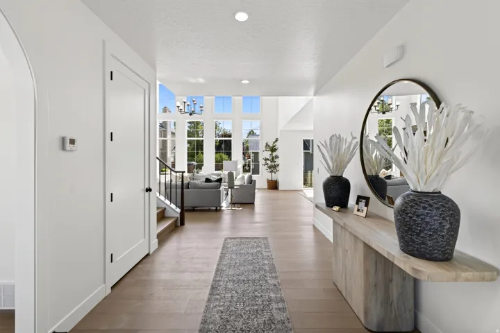 Entryway featuring wood-finish flooring, white walls, and an arched doorway