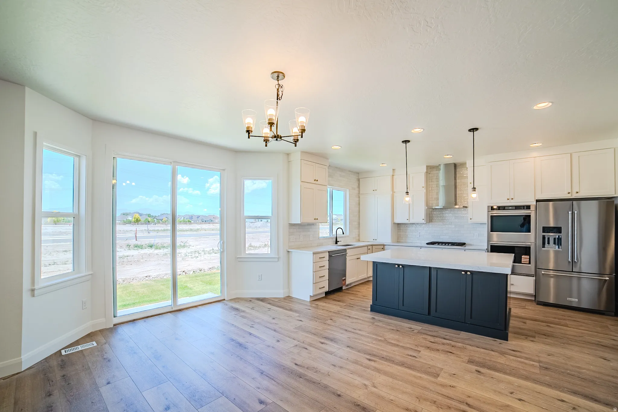 Open-concept kitchen and dining area featuring wide plank wood-finish flooring
