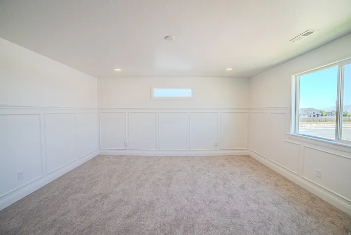 Bright interior space featuring wainscoting, recessed lighting, and soft gray carpeting