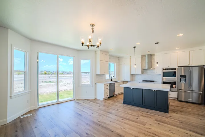 Open-concept kitchen and dining area featuring wide plank wood-finish flooring