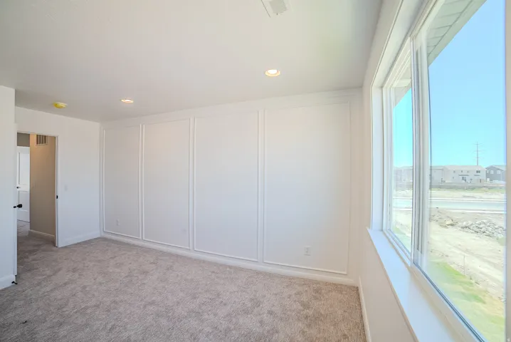 Wall paneling detailing, recessed lighting, and large windows with white trim