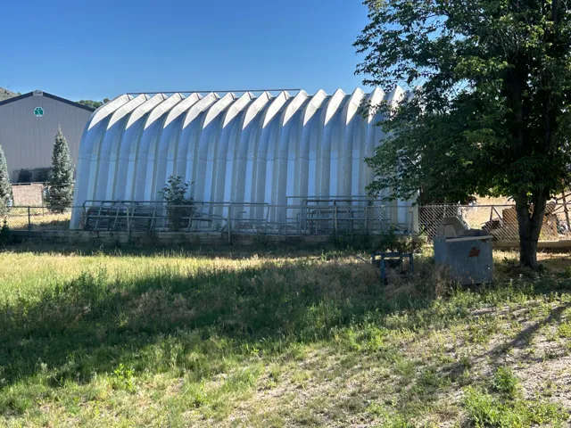 Quonset-style utility building featuring corrugated metal siding and a low-sloping roofline
