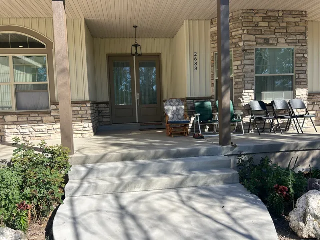 Inviting front porch featuring stone and vertical siding accents