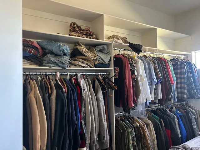 Integrated closet system featuring multiple hanging rods and overhead shelving
