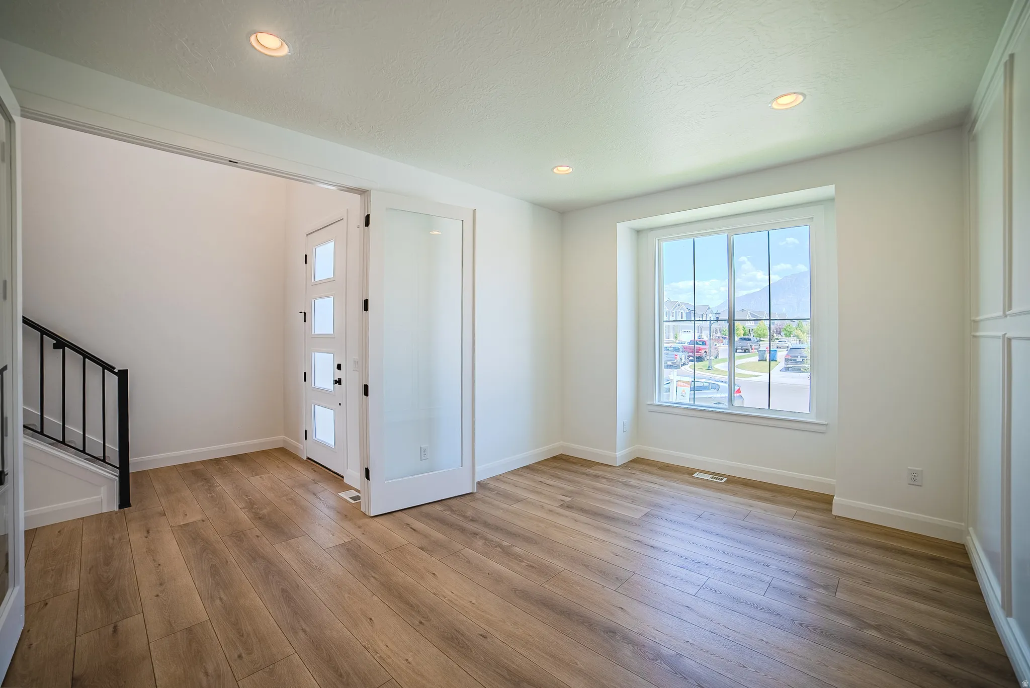 Interior space featuring wood-finish flooring, white walls, and recessed lighting