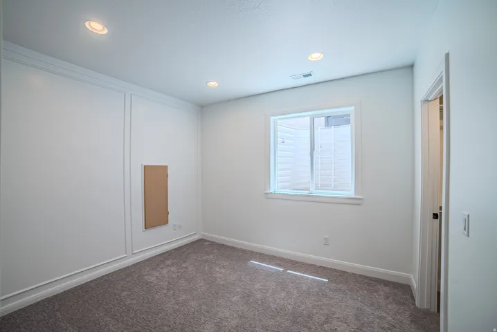 Carpeted room with recessed lighting, a window, and white trim molding