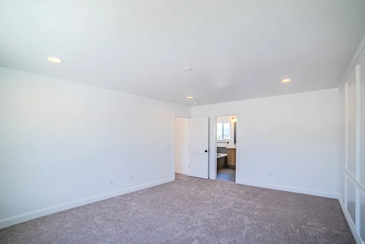 Spacious room with gray carpet flooring and recessed lighting