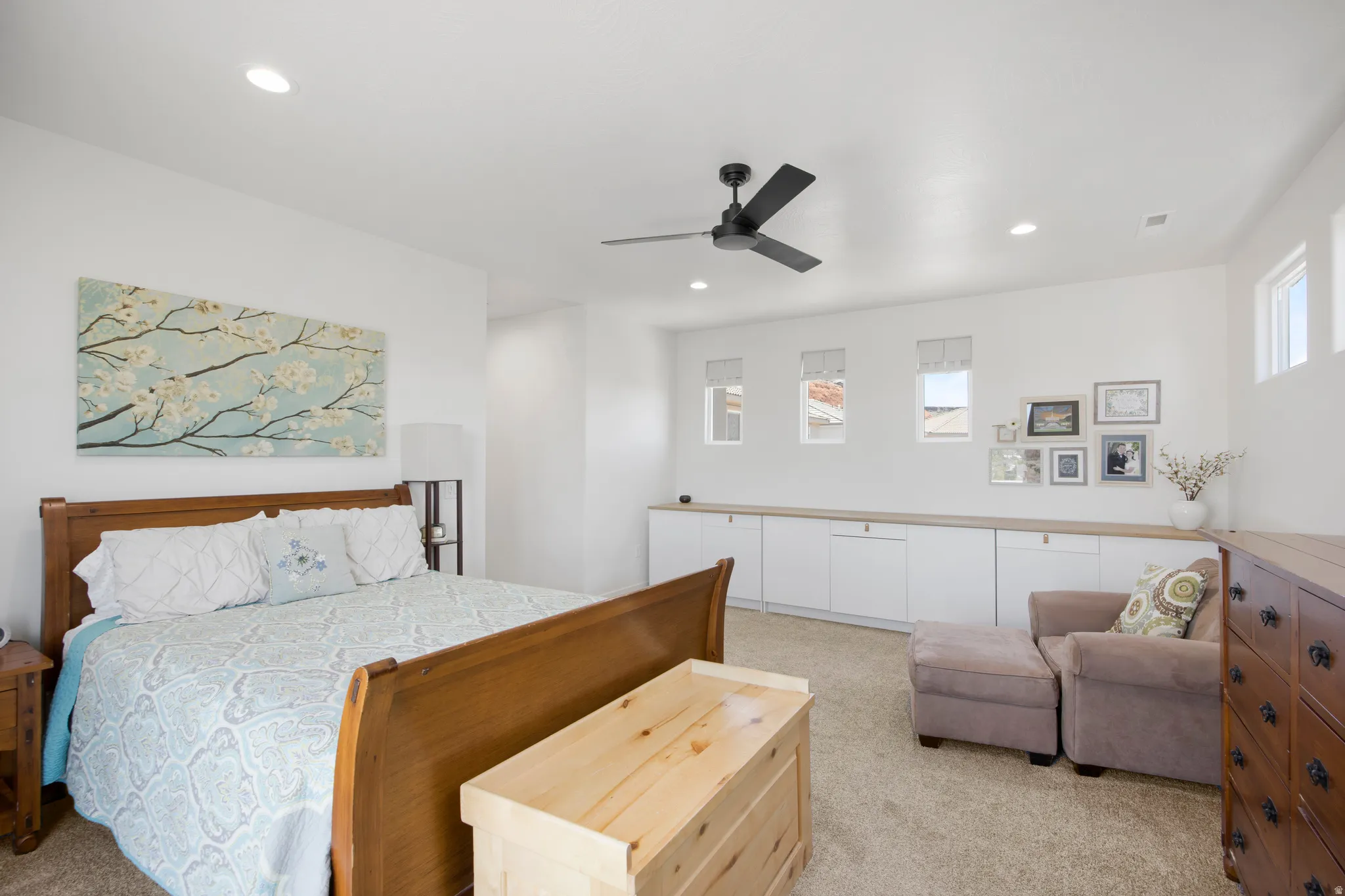 Spacious bedroom featuring recessed lighting, a ceiling fan, and a built-in cabinetry system with a wood-finish countertop