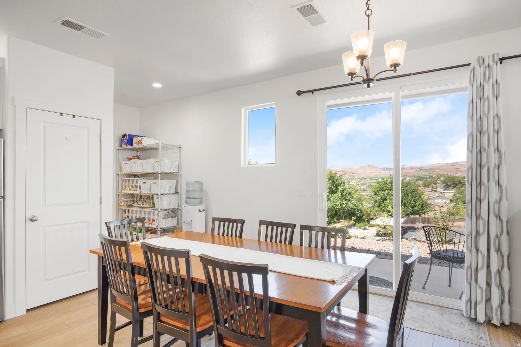 Dining area featuring a wood-finish table, a decorative chandelier, and light wood-finish flooring