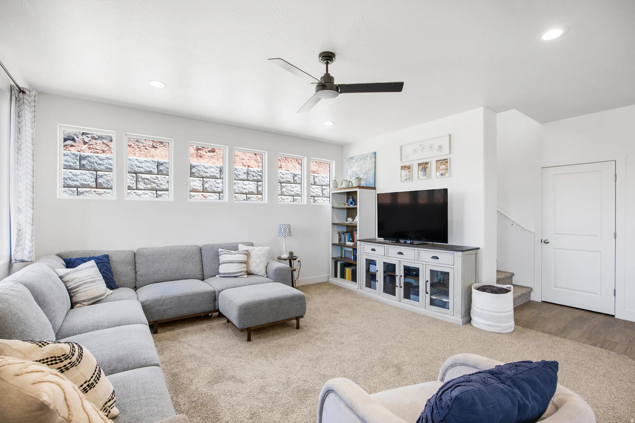 Open-concept living area featuring neutral carpeting and recessed lighting