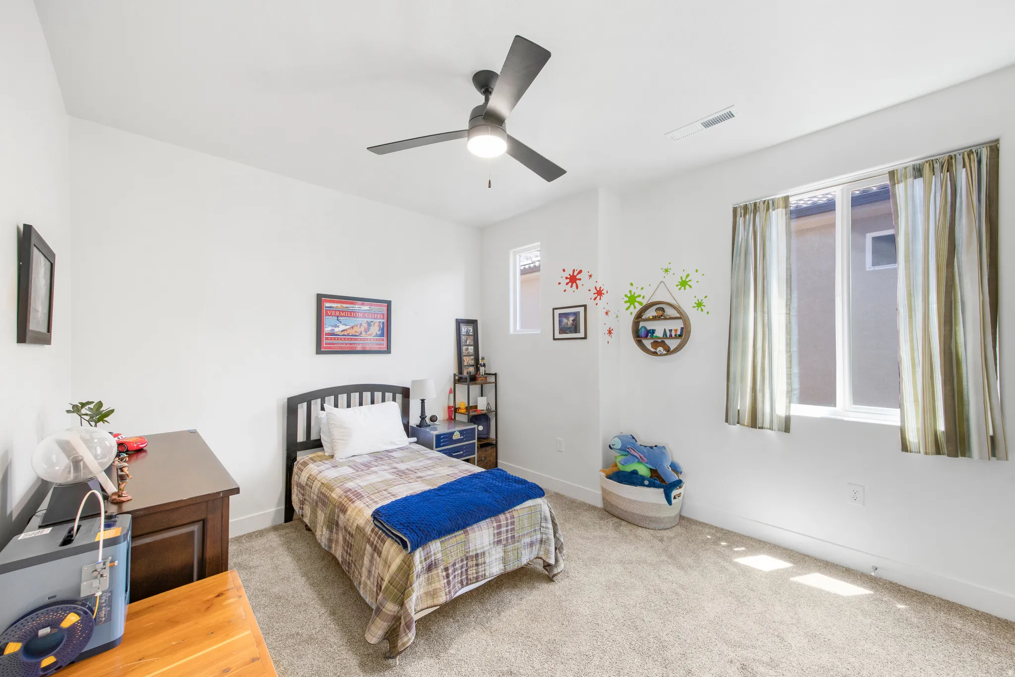Bedroom featuring neutral carpeting, white walls, and a ceiling fan with integrated lighting