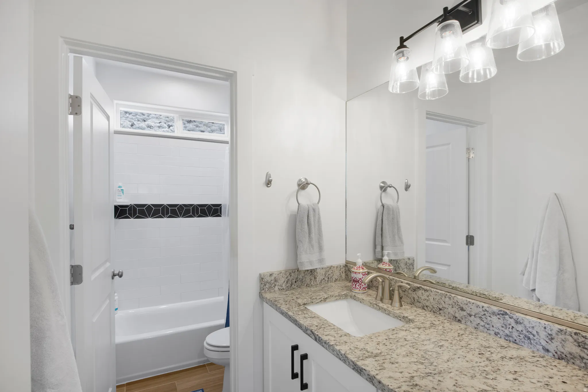 Bathroom vanity featuring a light-toned granite countertop with an undermount sink