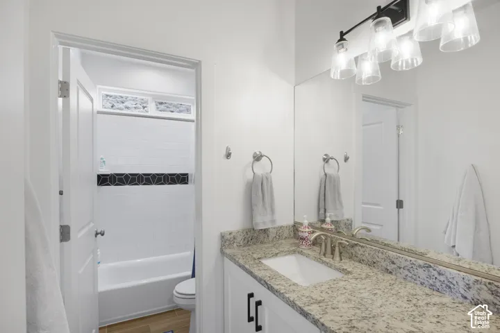 Bathroom vanity featuring a light-toned granite countertop with an undermount sink