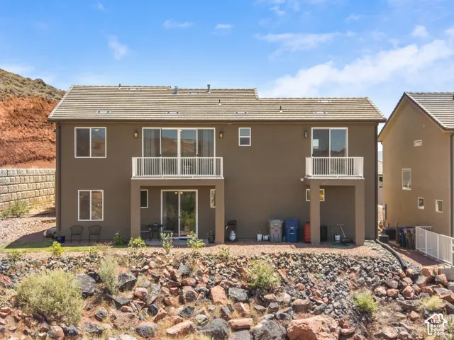 Two-story exterior featuring a brown stucco finish and a light-colored tile roof