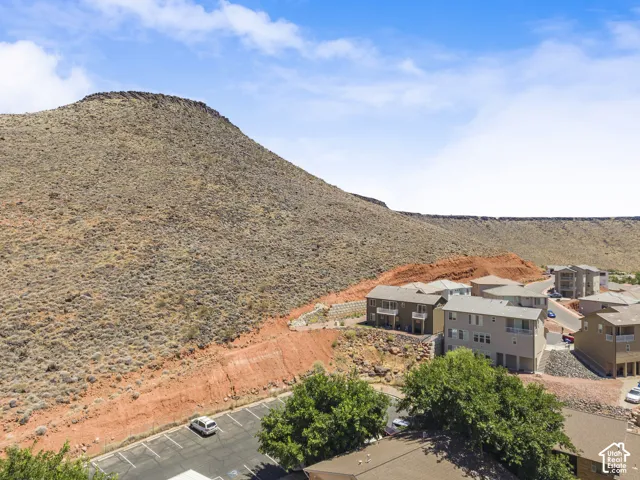 Multi-story residential buildings with balconies situated at the base of a rugged mountain