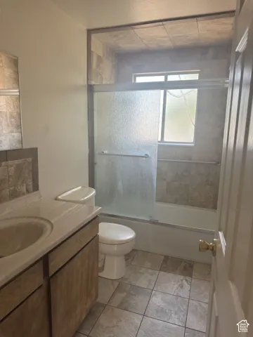 Bathroom featuring a tiled tub and shower combination with a sliding glass door