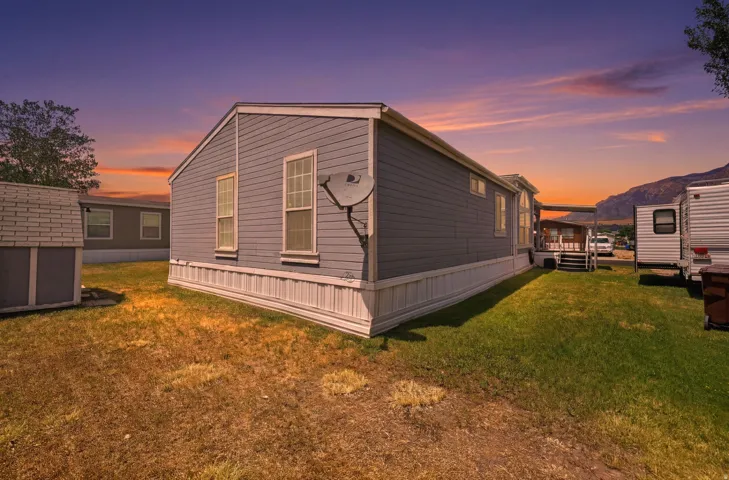 Light gray siding exterior with white trim and white skirting