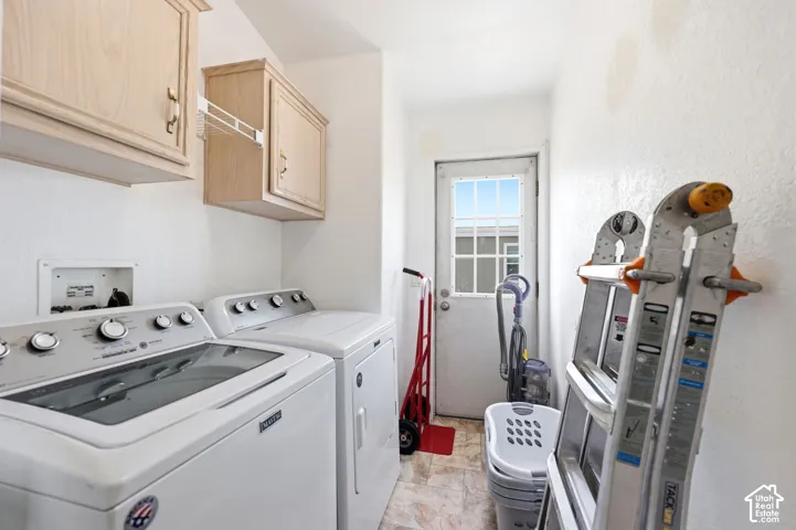Utility room featuring upper cabinetry, a white exterior door with window panes, and patterned flooring