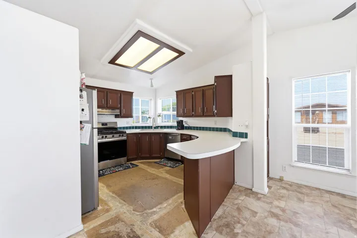 Kitchen featuring brown cabinetry, white countertops, and a tiled backsplash