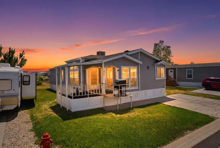Light gray siding exterior with white trim and a covered front porch featuring white railings