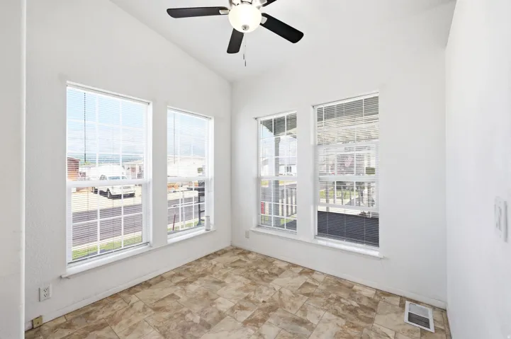 Room with vaulted ceiling, ceiling fan, and five windows