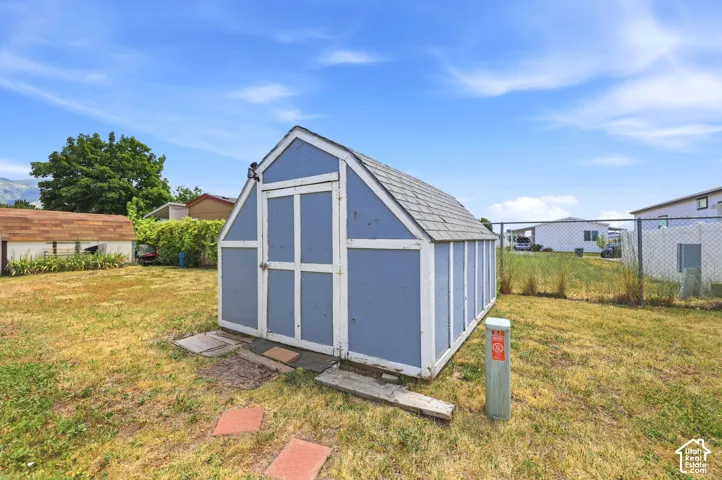 Blue painted storage shed with a gabled roof and light gray shingles