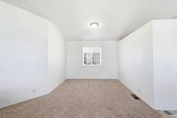 Neutral wall finishes and light brown carpeting