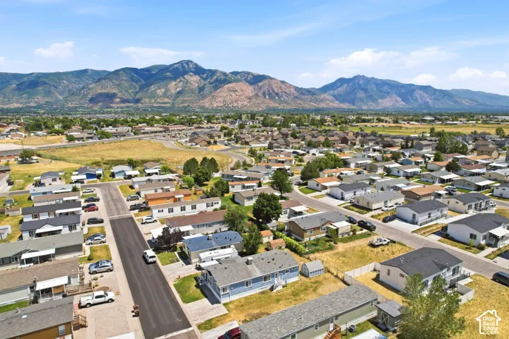 Residential neighborhood with paved streets and mature landscaping, set against a backdrop of distant mountains