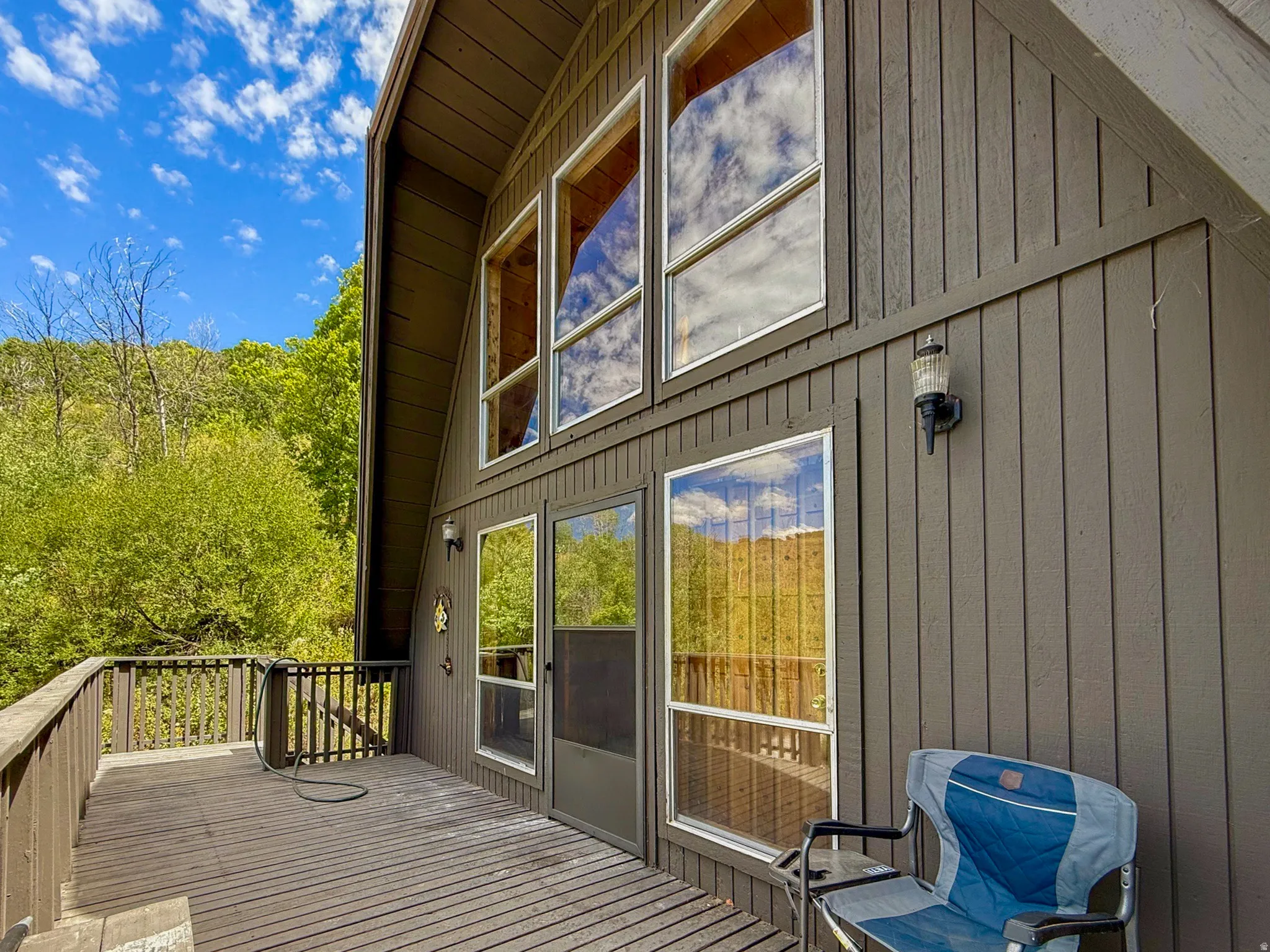A-frame exterior featuring vertical wood siding and a multi-level deck with a wood railing
