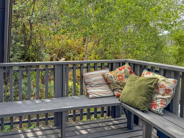 Outdoor deck featuring a dark gray railing and built-in bench seating