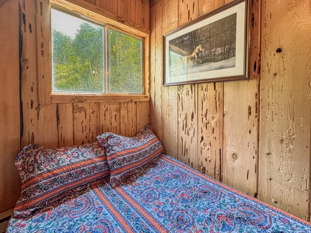 Wood-paneled room featuring a window overlooking natural scenery